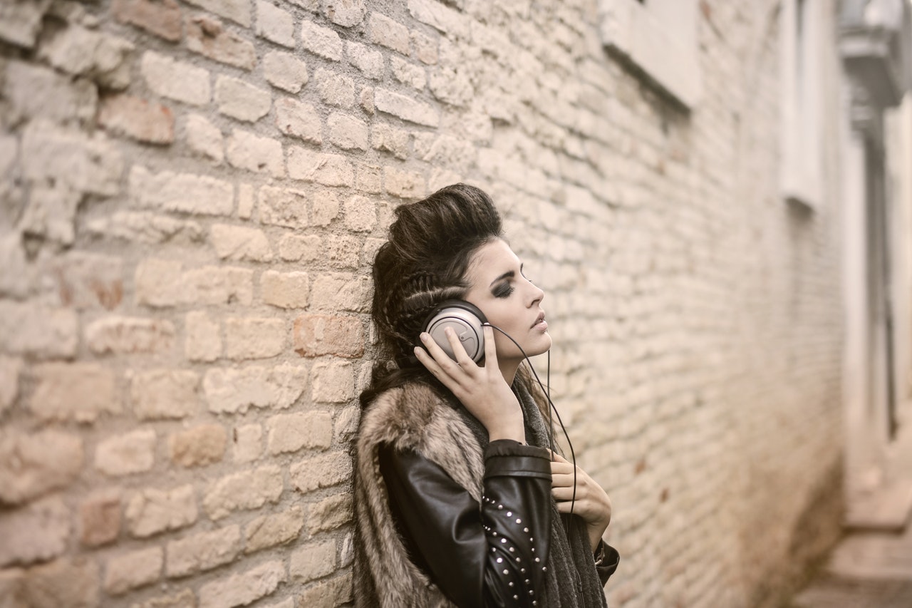 Kobieta w stylizacji rockowej słucha muzyki